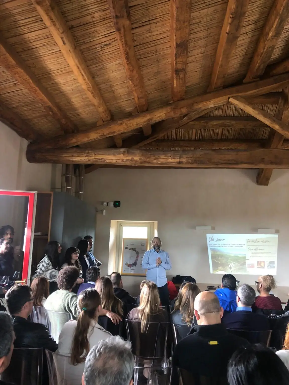 Guests attending a luxury event presentation inside a rustic Sicilian vineyard venue.