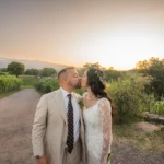 Sposa e sposo che si baciano al tramonto in un vigneto siciliano con vista sull’Etna durante un matrimonio di lusso.
