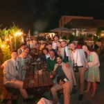 Invitati che si godono una cena di matrimonio di lusso all’aperto in Sicilia durante una celebrazione serale.