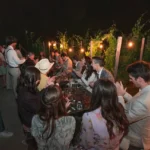 Invitati a un matrimonio riuniti all’aperto durante un intimo ricevimento di lusso in Sicilia di notte.