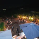 Vista notturna di una location per matrimoni di lusso in Sicilia con invitati, luci e atmosfera di festa all’aperto.