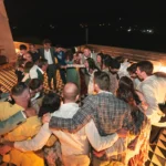 Invitati che ballano e festeggiano durante una vivace festa di matrimonio di lusso in Sicilia di notte.